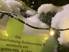 Ein Weihnachtsbaumanhänger in der Form eines Lebkuchenmanns. Darauf steht: Die Ortsteilvertretung Schönwalde II wünscht ein gutes neues Jahr.